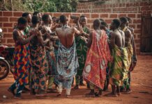 Канада и Бенин укрепляют стратегическое партнерство A vibrant cultural ceremony in Benin featuring a group in traditional clothing engaging in a ritual dance.