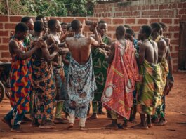 A vibrant cultural ceremony in Benin featuring a group in traditional clothing engaging in a ritual dance.