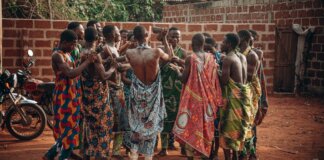 A vibrant cultural ceremony in Benin featuring a group in traditional clothing engaging in a ritual dance.