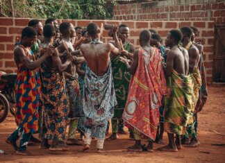 Канада и Бенин укрепляют стратегическое партнерство A vibrant cultural ceremony in Benin featuring a group in traditional clothing engaging in a ritual dance.