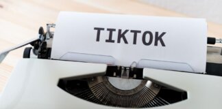 A vintage typewriter holding paper with TikTok written, symbolizing modern social media trends.