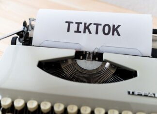 Meta призывает TikTok и YouTube ввести ограничения для подростков A vintage typewriter holding paper with TikTok written, symbolizing modern social media trends.