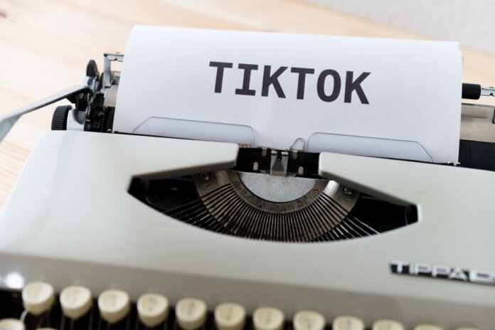 A vintage typewriter holding paper with TikTok written, symbolizing modern social media trends. A vintage typewriter holding paper with TikTok written, symbolizing modern social media trends.