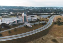 Канада и Ньюфаундленд поддержат работников, пострадавших от тарифов Aerial shot of the Confederation Building in Newfoundland with surrounding landscape and roads.