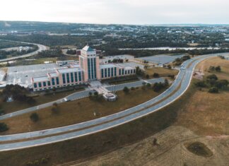 Канада и Ньюфаундленд поддержат работников, пострадавших от тарифов Aerial shot of the Confederation Building in Newfoundland with surrounding landscape and roads.