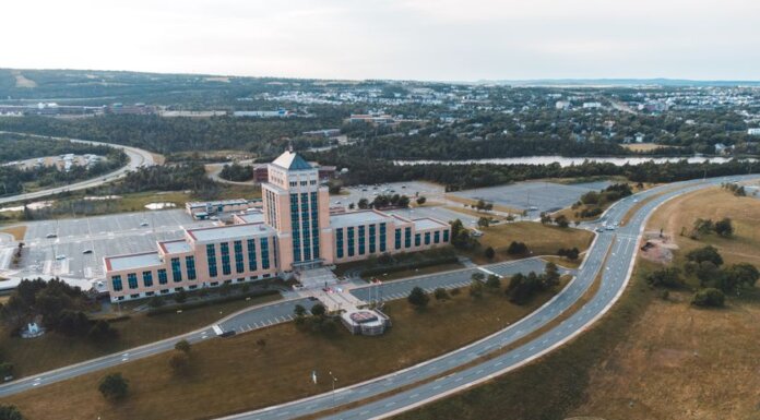 Aerial shot of the Confederation Building in Newfoundland with surrounding landscape and roads.