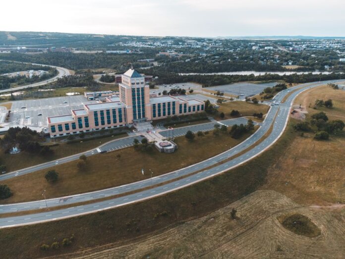 Aerial shot of the Confederation Building in Newfoundland with surrounding landscape and roads.