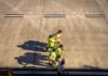 Meta запустила бесплатную профессиональную программу в США Aerial view of airport workers walking on the tarmac in Buenos Aires on a sunny day.