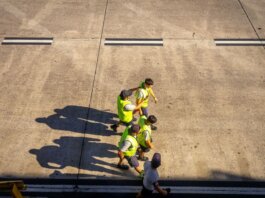 Aerial view of airport workers walking on the tarmac in Buenos Aires on a sunny day.