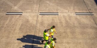 Meta запустила бесплатную профессиональную программу в США Aerial view of airport workers walking on the tarmac in Buenos Aires on a sunny day.