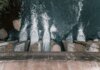 Aerial view of cascading water over a concrete dam showcasing turbulent flow and water management.