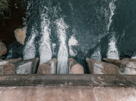 Aerial view of cascading water over a concrete dam showcasing turbulent flow and water management.