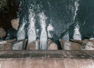 BC Hydro покупает Island Generation для надёжности энергоснабжения Aerial view of cascading water over a concrete dam showcasing turbulent flow and water management.