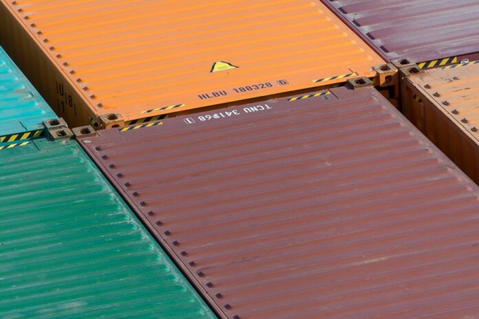 Aerial view of vibrant cargo containers arranged in a pattern, emphasizing logistics and transportation. Aerial view of vibrant cargo containers arranged in a pattern, emphasizing logistics and transportation.