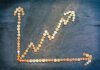 An upward trend graph made from coins representing financial growth and success.