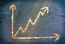 Британская Колумбия снова привязывает рост арендной платы к инфляции An upward trend graph made from coins representing financial growth and success.