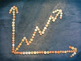 An upward trend graph made from coins representing financial growth and success.