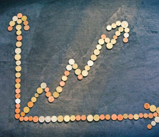 An upward trend graph made from coins representing financial growth and success.