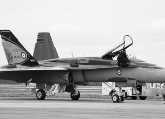 Canadian fighter jet on airstrip. Monochrome image showcasing aviation and military theme.