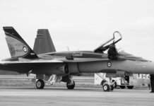 Canadian fighter jet on airstrip. Monochrome image showcasing aviation and military theme.