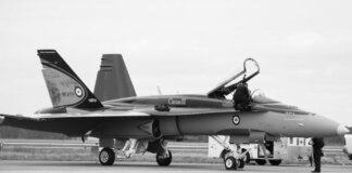 Canadian fighter jet on airstrip. Monochrome image showcasing aviation and military theme.