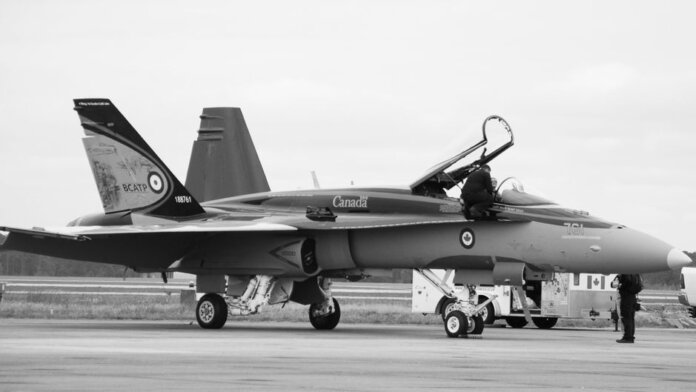 Canadian fighter jet on airstrip. Monochrome image showcasing aviation and military theme. Canadian fighter jet on airstrip. Monochrome image showcasing aviation and military theme.