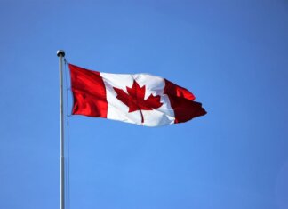 Canadian flag waving proudly against a clear blue sky in Victoria, BC.