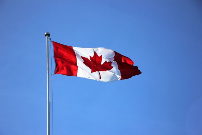 Canadian flag waving proudly against a clear blue sky in Victoria, BC. Canadian flag waving proudly against a clear blue sky in Victoria, BC.