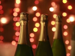 Champagne bottles in a warm festive setting with sparkling bokeh lights for celebration.