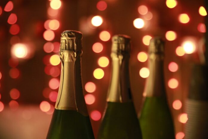 Champagne bottles in a warm festive setting with sparkling bokeh lights for celebration. Champagne bottles in a warm festive setting with sparkling bokeh lights for celebration.