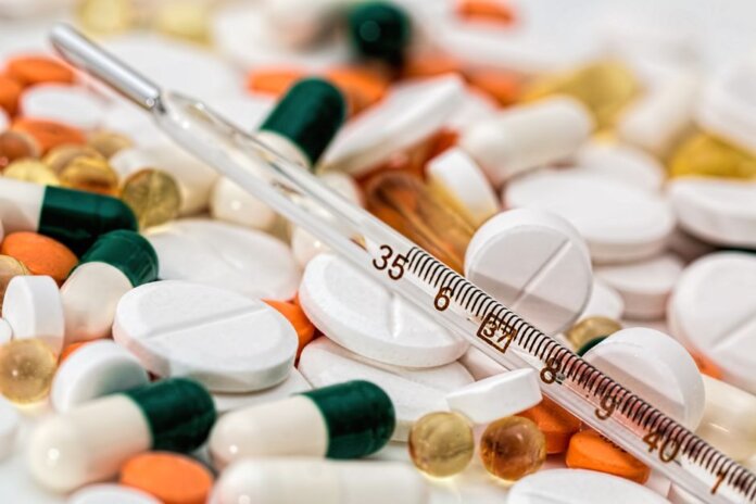 Close-up image showing various pills and a thermometer, emphasizing health and medicine. Close-up image showing various pills and a thermometer, emphasizing health and medicine.