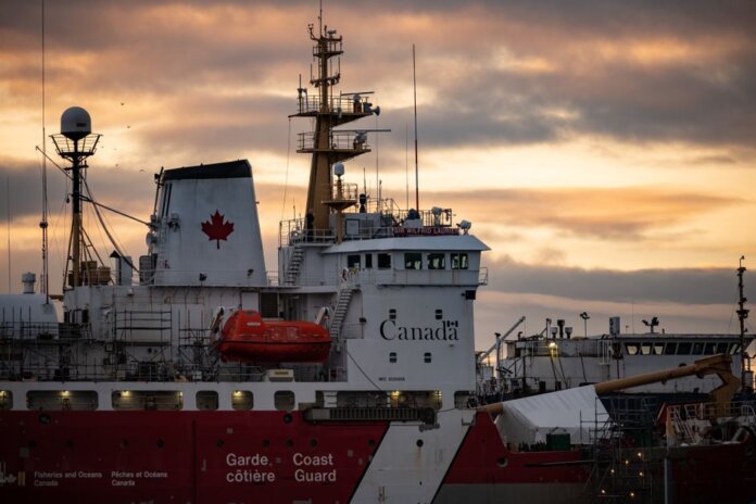 Close-up of a Canadian Coast Guard ship docked at sunset, showcasing maritime details. Close-up of a Canadian Coast Guard ship docked at sunset, showcasing maritime details.