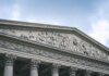 Close-up of a classical architectural pediment with detailed sculptures and columns.