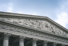 Close-up of a classical architectural pediment with detailed sculptures and columns.