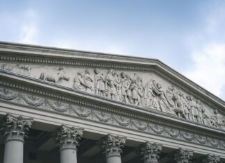 Close-up of a classical architectural pediment with detailed sculptures and columns.