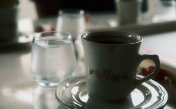 TransLink и Trees выпустили фирменный кофе и чай для пассажиров Close-up of a floral coffee cup and water glass on a table setting.