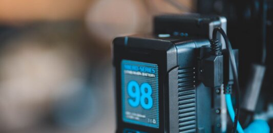 Close-up of a high-capacity portable battery with digital display showing 98 percent charge.