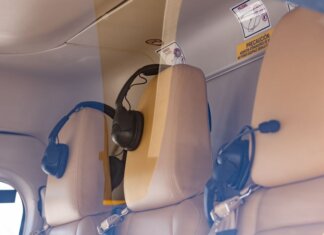 Close-up of a luxurious helicopter interior with leather seats and headphones.
