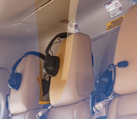 Close-up of a luxurious helicopter interior with leather seats and headphones.