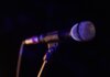 Close-up of a microphone set up on stage, highlighting concert ambiance.