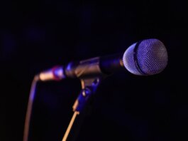 Министр Миллер приветствует участие Канады в «Евровидении» Close-up of a microphone set up on stage, highlighting concert ambiance.