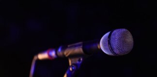 Close-up of a microphone set up on stage, highlighting concert ambiance.