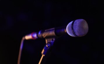 Министр Миллер приветствует участие Канады в «Евровидении» Close-up of a microphone set up on stage, highlighting concert ambiance.
