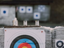 Close-up of archery targets and steel cans used for target practice at an outdoor range.