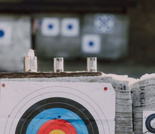 Close-up of archery targets and steel cans used for target practice at an outdoor range.