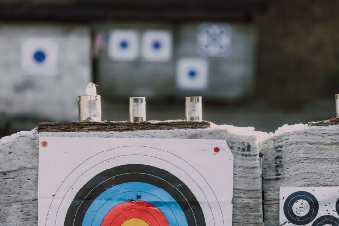 Close-up of archery targets and steel cans used for target practice at an outdoor range. Close-up of archery targets and steel cans used for target practice at an outdoor range.