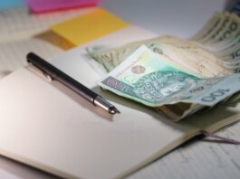 Close-up of Polish Zloty banknotes on an open notebook with a pen, symbolizing finance and budgeting.