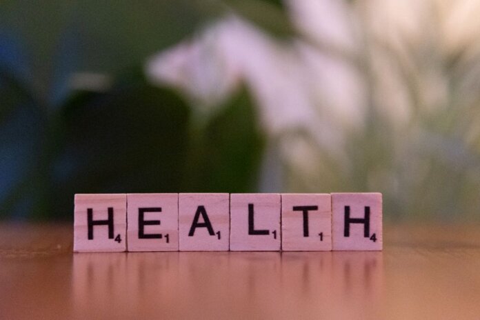 Close-up of Scrabble tiles spelling 'Health' on a wooden table with a blurred background. Close-up of Scrabble tiles spelling 'Health' on a wooden table with a blurred background.