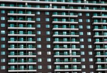 Консерваторы критикуют либералов за повторные обещания по жилью Close-up view of a modern apartment building facade with balconies in Montreal, Canada.