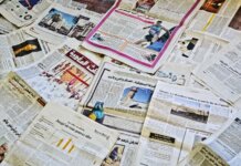 Канада открыла аккредитацию СМИ на конференцию по возвращению украинцев Close-up view of various newspapers laid out, showcasing diverse headlines and articles.